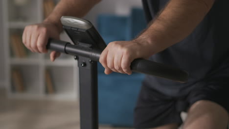 middle-aged-man-with-moustache-is-training-at-home-on-stationary-bicycle-caring-about-health-and-healthy-breathing-rotating-pedals